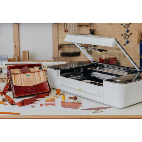 Glowforge Pro Laser engraver with a leather bag example to the left of it.